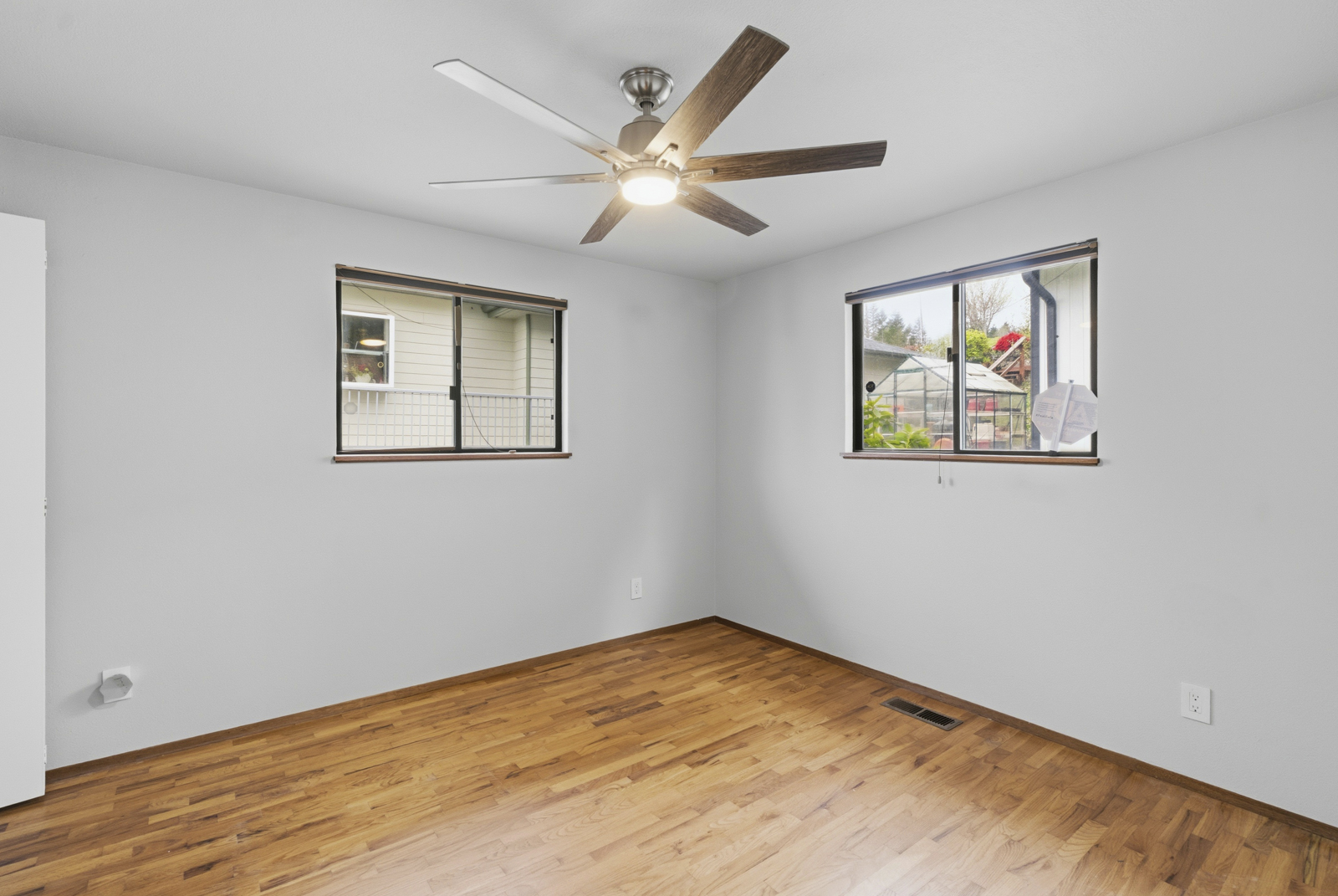 Second bedroom with natural light and hardwood floors